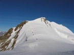 La risalita dal piccolo slargo verso la Punta Felik, sullo sfondo la cima del Castore con la lunga cresta