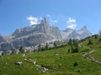 La vegetazione si assottiglia, mente di fronte a noi si intravedono i massi che si dovranno superare per entrare nella conca del rifugio. Sullo sfondo il Castello del Tuckett