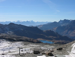 La zona di Plan Maison e la relativa funivia che porta al colle e al rifugio Gude del Cervino sul vicino Testa Grigia, in basso il laghetto du Tramail